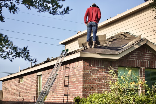 Man in red working on roof
