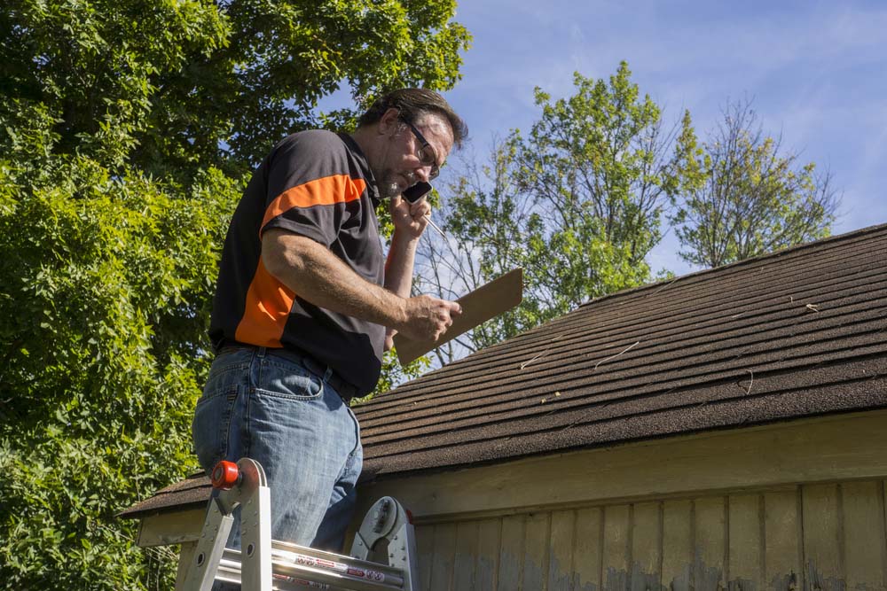 a roofer making an estimate on roof repair