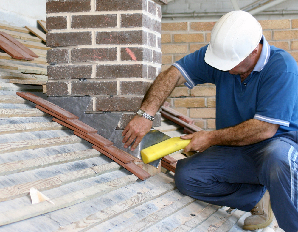 a roofer installing flashing on a roof
