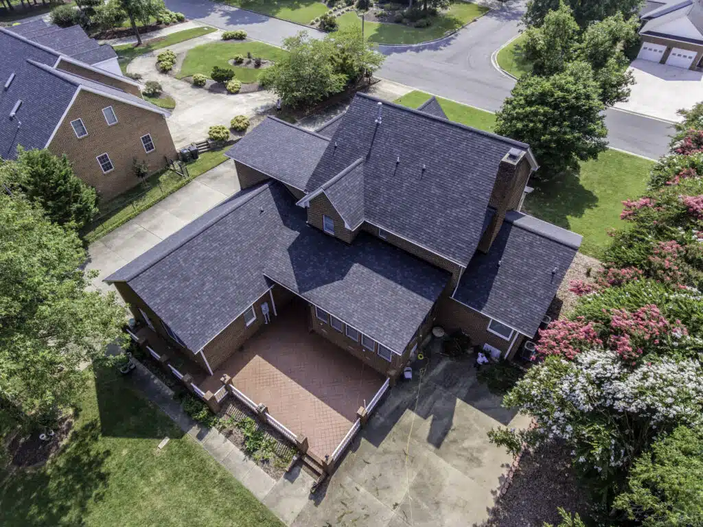Aerial view of a residential home with roofing, siding, windows, and gutters