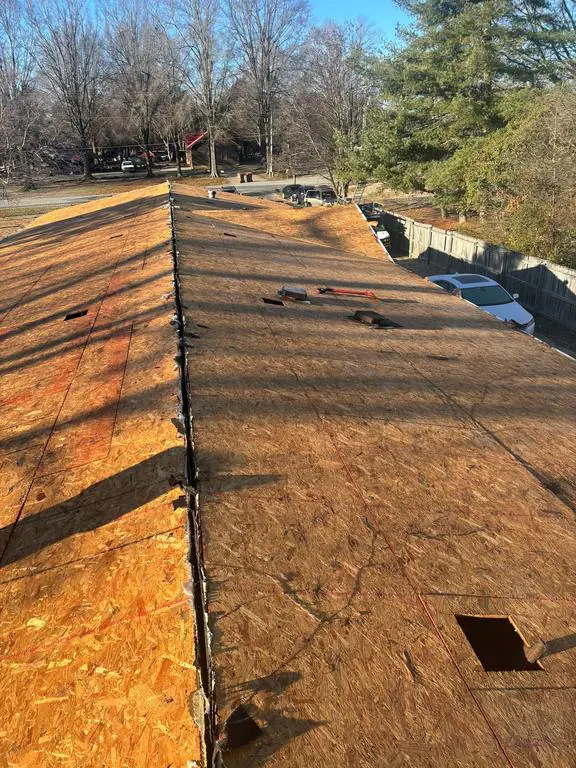 Double-wide manufactured home with the existing roof removed before replacement